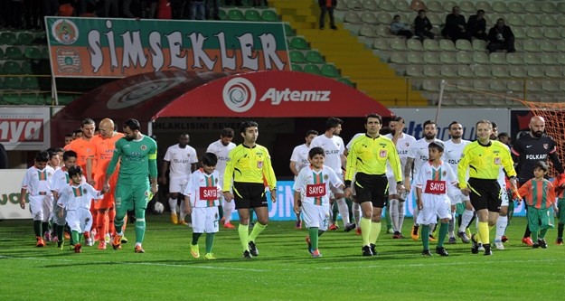 Alanyaspor, Karşıyaka karşısında 2-0'lık skor avantajını koruyamadı, Adana Demirspor maçında olduğu gibi yine son dakika yediği golle hem 2 puandan hemde liderlikten oldu. 

PTT 1. Lig'in 24. haftasında oynanan karşılaşmada Multigroup Alanyaspor sahasında Karşıyaka ile 2-2 berabere kaldı. 

STAT: Alanya Oba Stadı

HAKEMLER: Süleyman Abay, Gökmen Olgaç, Candaş Elbil

MULTİGROUP ALANYASPOR: Haydar- Yasin, Ahmet, Sezer, Kerem Can, Timuçin, Emre, Tayfur (Dk.78 Perovic), Barış (Dk.55 Caner), Sinan (Dk.84 Efecan), Ayite

KARŞIYAKA: Behram- Zeki, Tayfun (Dk.60 Şahin), Ömer Can, Tisdell, Can (Dk.68 Mahmut), Youssef, Efe Halil, Mustafa, Berkay Can, İbrahim (Dk.46 Gökhan)

GOLLER: Dk.1 Sinan, Dk.45 Timuçin (MultigroupAlanyaspor), Dk.51 Youssef, Dk.89 Gökhan (Karşıyaka)

KIRMIZI KART: Dk.90 Ayite (MultigroupAlanyaspor)

SARI KARTLAR: Sinan, Barış, Emre (MultigroupAlanyaspor), Can, Youssef, Ömer Can, Behram (Karşıyaka)

Karşılaşmanın 20. saniyesinde turuncu yeşilliler faul atışını çabuk kullandı. Tayfur’un pasında Sinan kaleciyi çalımlayarak topu ağlarla buluşturdu: 1-0. 18. dakikada Kerem Can’ın ortasında Tayfur kafa vurdu, top auta çıktı. 20. dakikada Zeki’nin ortaladığı topta Tisdell’in kafa vuruşu az farkla auta gitti. 21. dakikada Tisdell’in uzaktan sert şutunu Haydar son anda kornere çeldi. 30. dakikada Kerem Can’ın ortasında savunmadan dönen topa bu oyuncu ayağının dışıyla sert vurdu top direğin üstünden auta gitti. 35. dakikada Yasin sağ kanattan ceza alanına sokuldu. Bu oyuncunun içeriye sert çevirdiği topu Tayfur güçlükle kontrol etti ancak tehlikeyi savunma uzaklaştırdı. 37. dakikada Ayite, Tayfur’dan aldığı pasla uzaktan sert vurdu ancak top az farkla auta çıktı. 41. dakikada topu rakibinden kurtaran Barış geriden gelen Tayfur’un önüne bıraktı. Bu oyuncunun şutunu kaleci güçlükle kornere çeldi. 45. dakikada gelişen ani atakta Kerem Can’ın soldan ortasına Ayite kayarak vurdu, direkten dönen topu Timuçin ağlarla buluşturdu: 2-0. Karşılaşmanın ilk yarısı 2-0 turuncu yeşilli takımın üstünlüğüyle tamamlandı. 

50. dakikada Emre'nin pasında savunmanın arasında topu kontrol eden Sinan dönerek kaleyi vurdu kaleci Behram gole izin vermedi. 51. dakikada Youssef uzaktan vurdu, yerden giden top köşeden filelere gitti: 2-1. 63. dakikada Emre topu rakibinden kurtararak Ayite'ye verdi. Ceza alanına giren Ayite açısını kaybetti ancak sağ çaprazdan kaleye vurdu. Top yan ağlarda kaldı. 83. Dakikada Youssef’in ortasında Gökhan’ın kafa vuruşu üstten auta gitti. 88. Dakikada Efecan’ın pasında savunmanın arasında topla buluşan Perovic bekletmeden kaleye vurdu ancak top az farkla yandan auta gitti. 89. dakikada turuncu yeşilli savunma topu ceza yayında kaptırdı. Solda boşta kalan Gökhan sert bir vuruşla topu Haydar’ın solundan filelere gönderdi: 2-2. 90. Dakikada rakibine faul yapan Ayite kırmızı kartla oyundan atıldı. 90+5. dakikada Efecan rakibinden sıyrılarak topu Emre’ye aktardı. Bu oyuncu uydun durumda kaleye vurmak yerine pas vermeyi tercih edince top auta gitti. Karşılaşma 2-2 berabere sona erdi. 

İşte PTT 1.Lig Puan Durumu

1.ADANASPOR A.Ş.		41
2.MULTIGROUP ALANYASPOR		40
3.KARDEMİR KARABÜKSPOR		40
4.ADANA DEMİRSPOR		39
5.GİRESUNSPOR		        36
6.VARTAŞ ELAZIĞSPOR		36
7.BALIKESİRSPOR           	33
8.GÖZTEPE A.Ş.		        33
9.GAZİANTEP B.Ş. BLD.SPOR	32
10.ALTINORDU A.Ş.		32
11.BOLUSPOR	        	32
12.SAMSUNSPOR           	31
13.ALİMA YENİ MALATYASPOR	28
14.ŞANLIURFASPOR		25
15.1461 TRABZON		        23
16.KAYSERİ ERCİYESSPOR		21
17.DENİZLİSPOR          	21
18.KARŞIYAKA	        	19

Ceza Puanı Alan Takımlar

Takım Adı	Ceza Puanı

SAMSUNSPOR	3
DENİZLİSPOR	3