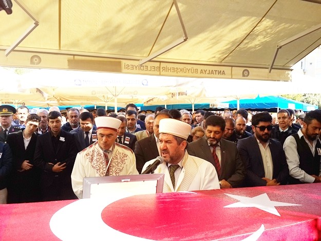 Alanyalı kahraman Özel Harekat Polisi Coşkun Nazilli, son yolculuğuna uğurlanıyor. Cenaze namazı kılınan Nazilli’nin naaşı, Garnizon Şehitliği’ne getirildi

Antalya İl Müftüsü Osman Artan tarafından kıldırılan cenaze namazının ardından Alanyalı kahraman Özel Harekat Polisi Coşkun Nazilli’nin naaşı Alanya Garnizon Şehitliği’ne getirildi. Kalabalık eşliğinde şehitliğe gelen cenaze aracından indirilen şehidin naaşı, omuzlara alındı. Cenaze törenine Antalya Valisi Muammer Türker, Türker’in eşlik ettiği baba Durmuş Nazilli, eşi Ayşegül Nazilli, Çocukları Göktürk ve Gökçe Nazilli, AK Parti Antalya Milletvekili Sena Nur Çelik, Alanya Kaymakamı Hasan Tanrıseven, Antalya Büyükşehir Belediye Başkanı Menderes Türel, Alanya Belediye Başkanı Adem Murat Yücel, AK Parti Antalya İl Başkanı Rıza Sümer, AK Parti Alanya İlçe Teşkilatı Başkanı Mustafa Berberoğlu ve çok sayıda vatandaş katıldı. Öte yandan şehit Coşkun Nazilli’nin Mardin’den gelen silah arkadaşları da şehitlikte.