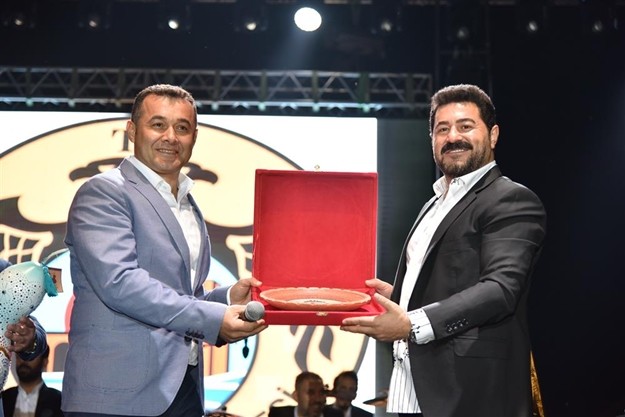 YÜCEL, KAYA’YA TEŞEKKÜR PLAKETİ VERDİ

Alanya Belediye Başkanı Adem Murat Yücel, Serkan Kaya’ya teşekkür plaketi takdim etti. Kaya’ya ayrıca üzerine resmi olan bir su kabağı portresi ve onun yanı sıra Alanya şalvarı, kasket, kuşak ve yelekten oluşan bir yöresel Alanya kıyafet takımı hediye edildi. Kasket ve yeleği sahnede giyen Kaya, Gökbel’in serin havasında böyle güzel bir organizasyonda yer aldığı için çok şanslı olduğunu söyledi ve emeği geçenlere teşekkür etti.