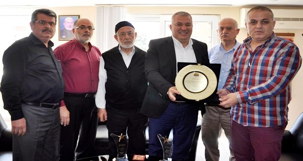 BAŞKAN ŞAHİN'DEN OBA KURUYEMİŞ'E PLAKET