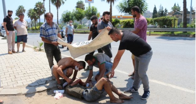 Kaza yapan yaralıyı güneşten branda ve şemsiye ile korudular