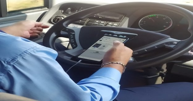 Şehirlerarası otobüs şoförünün bir elinde telefon, bir elinde çekirdek