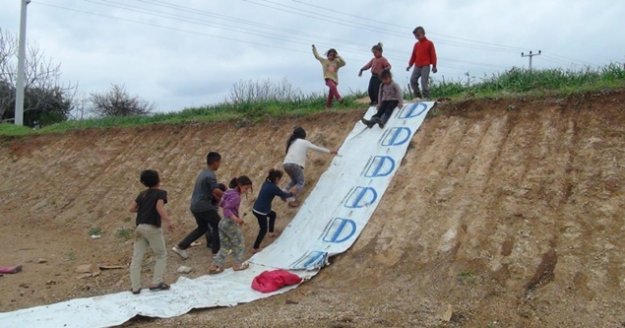 Kar yağmayan Antalya'da çocukların toprak üzerinde gülümseten kayak keyfi