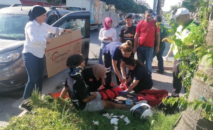 Yerde acı içerisindeki yaralıyı yakıcı güneşten kartonla korudular