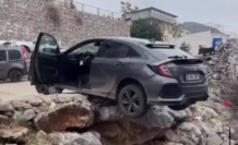 Alanya'da geri manevra yapan araç asılı kaldı