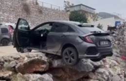 Alanya'da geri manevra yapan araç asılı kaldı