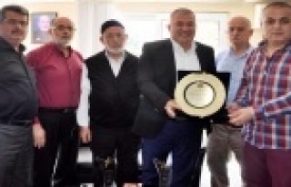 BAŞKAN ŞAHİN'DEN OBA KURUYEMİŞ'E PLAKET