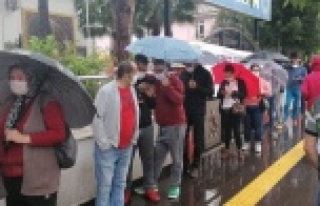 PTT önünde yağmur altında sosyal mesafesiz maaş...