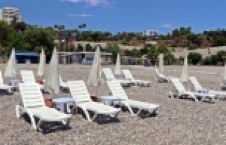 Sahilde şezlong ve şemsiyeler sosyal mesafeli yeni...