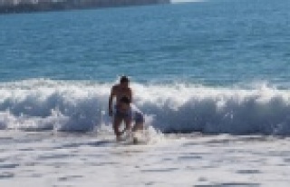 Karla kaplı dağların gölgesinde turistlerin deniz...