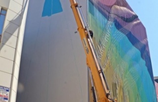 Kafasını kaldırıp vincin tepesinde elinde fırçayla...