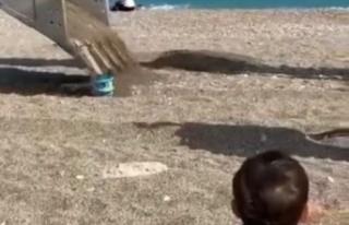 Sahilde oynayan minik çocuğun kum kovasını iş...